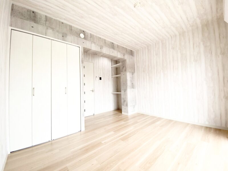 明るい木目調とコンクリート打ち放しの組み合わせが印象的な洋室(居間)