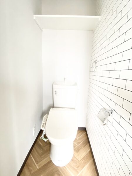 木目調とタイルの組み合わせが印象的なトイレは温水洗浄便座付き(ハウスクリーニング前)