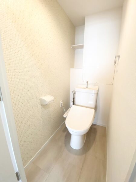 タイル調の壁紙がかわいらしいトイレは温水洗浄便座付き(内装)